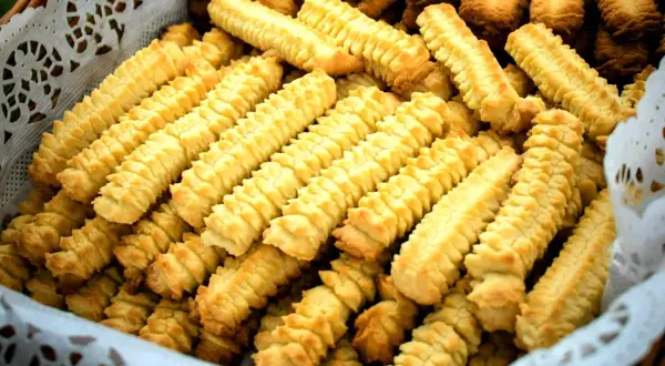 Koszyk pełen domowych, złocistych ciasteczek o charakterystycznym, karbowanym kształcie.